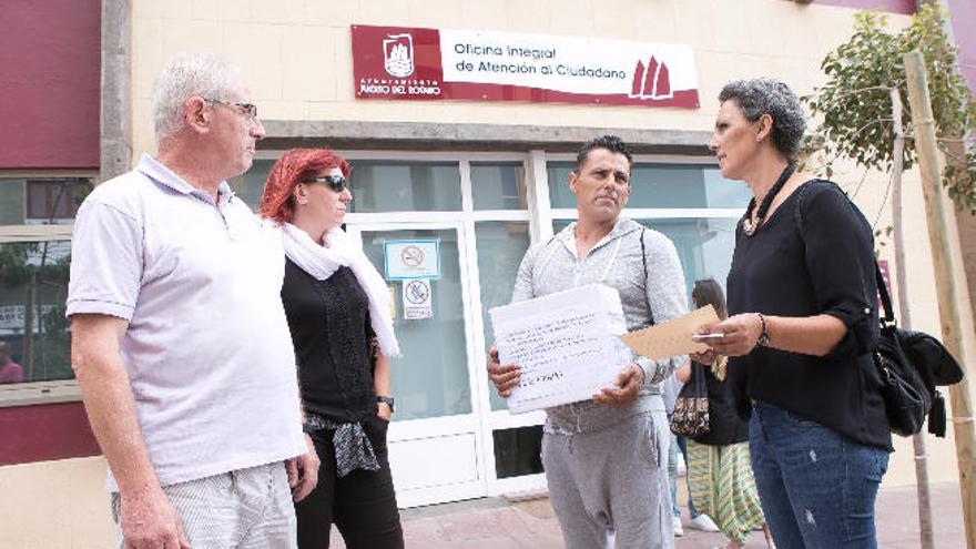 Un grupo de vecinos con las firmas contra el aparcamiento de pago.