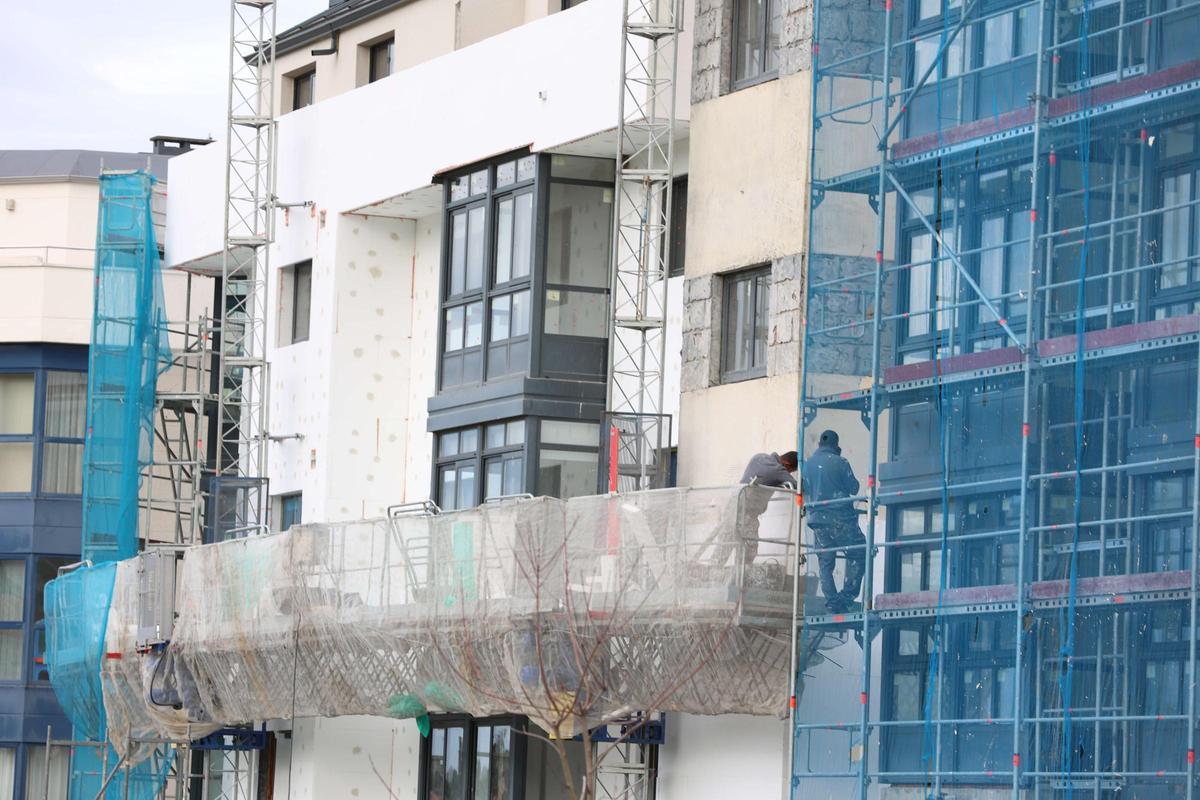 Trabajos en el edificio con viviendas en venta en Méndez Búa, en Carral, este miércoles.