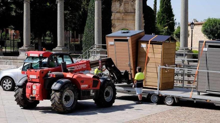 Los operarios descargan uno de los urinarios públicos en la plaza de la Catedral.