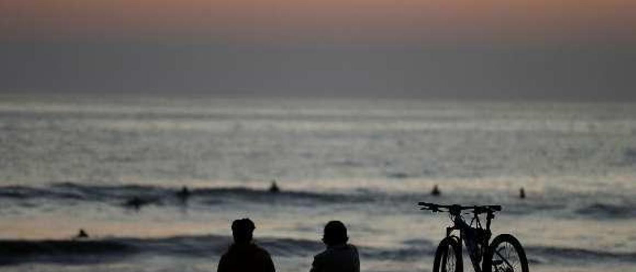 Bañistas al ponerse el sol en la playa de Viña del Mar (Chile). // Reuters