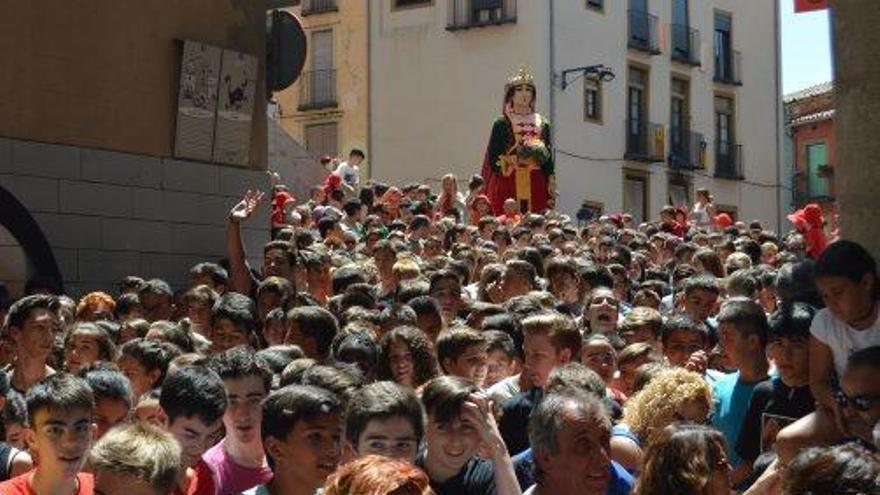 Una riuada de joves carrer Major avall amb la geganta de fons