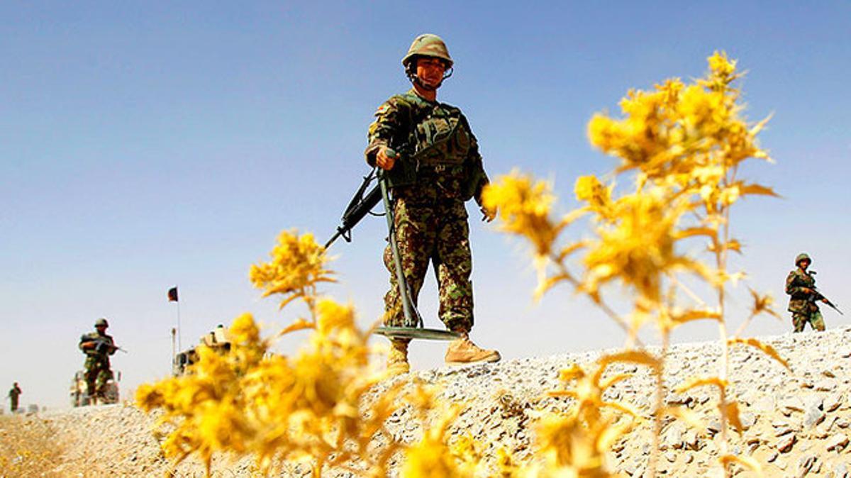 Un integrant de la Guàrdia Nacional de l’Afganistan patrulla pels voltants del seu camp d’entrenament amb un detector d’explosius.