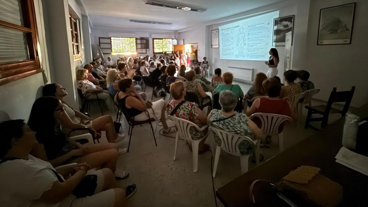 Sofía Polo, de pie, explica a los vecinos los síntomas de la ansiedad.