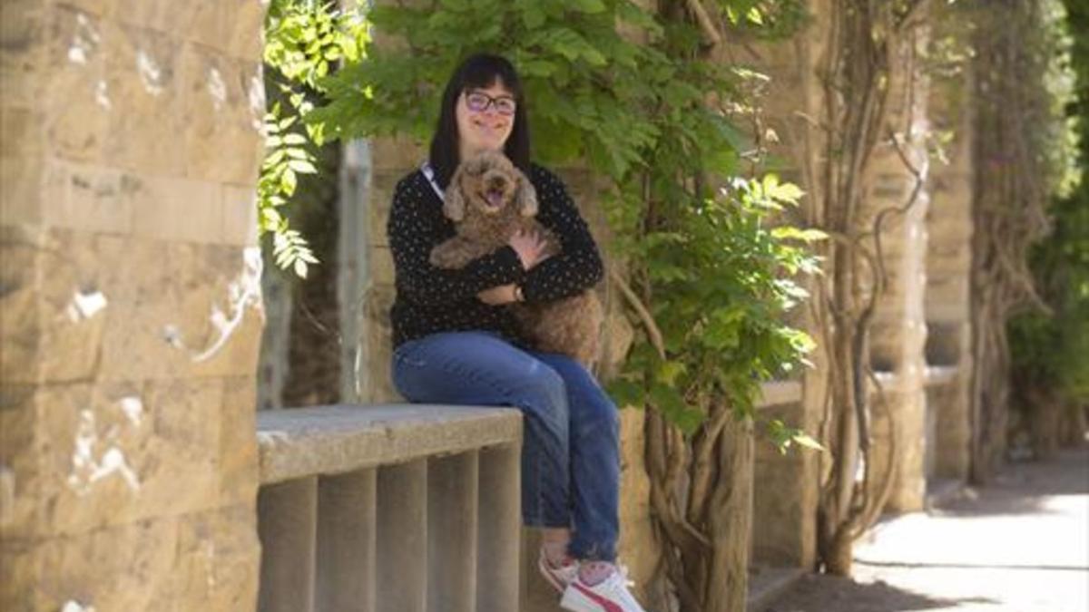 Anna Vives, con su perrita Bella, en el parque de Joan Miró, una zona verde próxima a su casa.