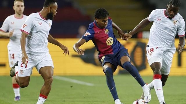 Lamine Yamal controla el balón rodeado de jugadores del Sevilla. |  Alberto Estévez