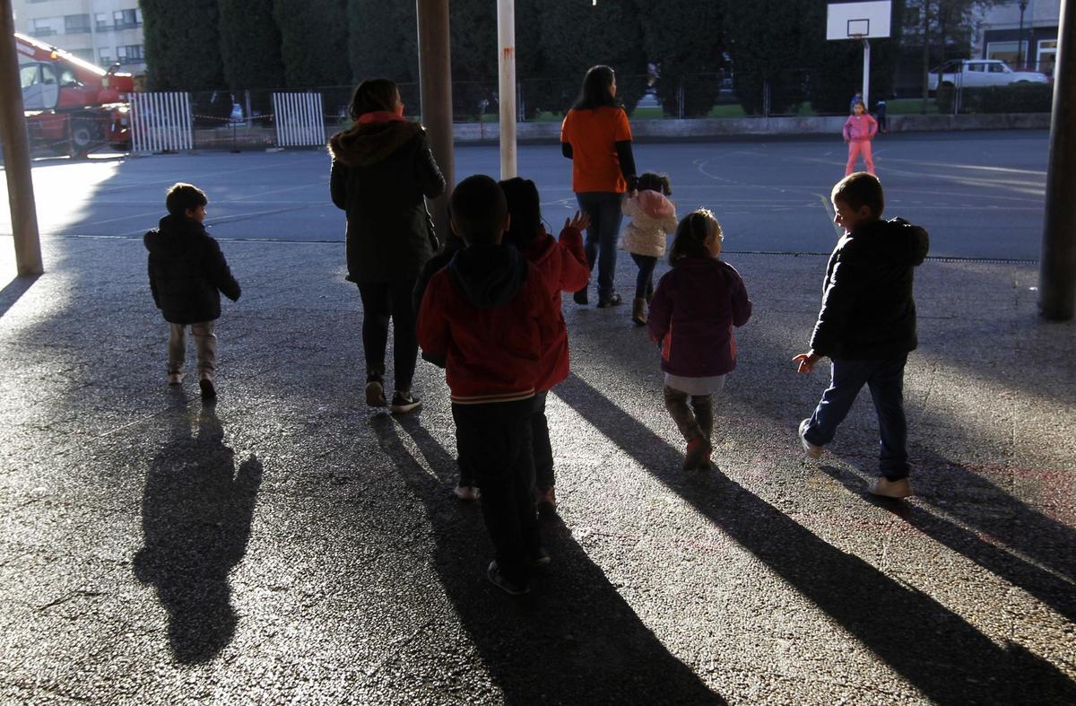 Niños y niñas en el patio de un colegio durante un programa de actividades para la conciliación de la vida laboral y familiar.