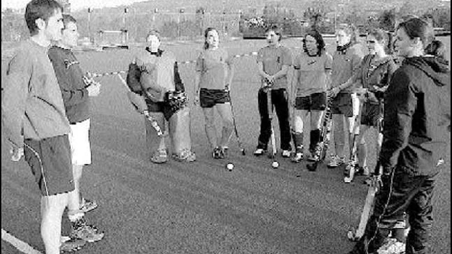 Pablo Blanco, a la izquierda, dando indicaciones a las jugadoras de hockey del Grupo Covadonga.