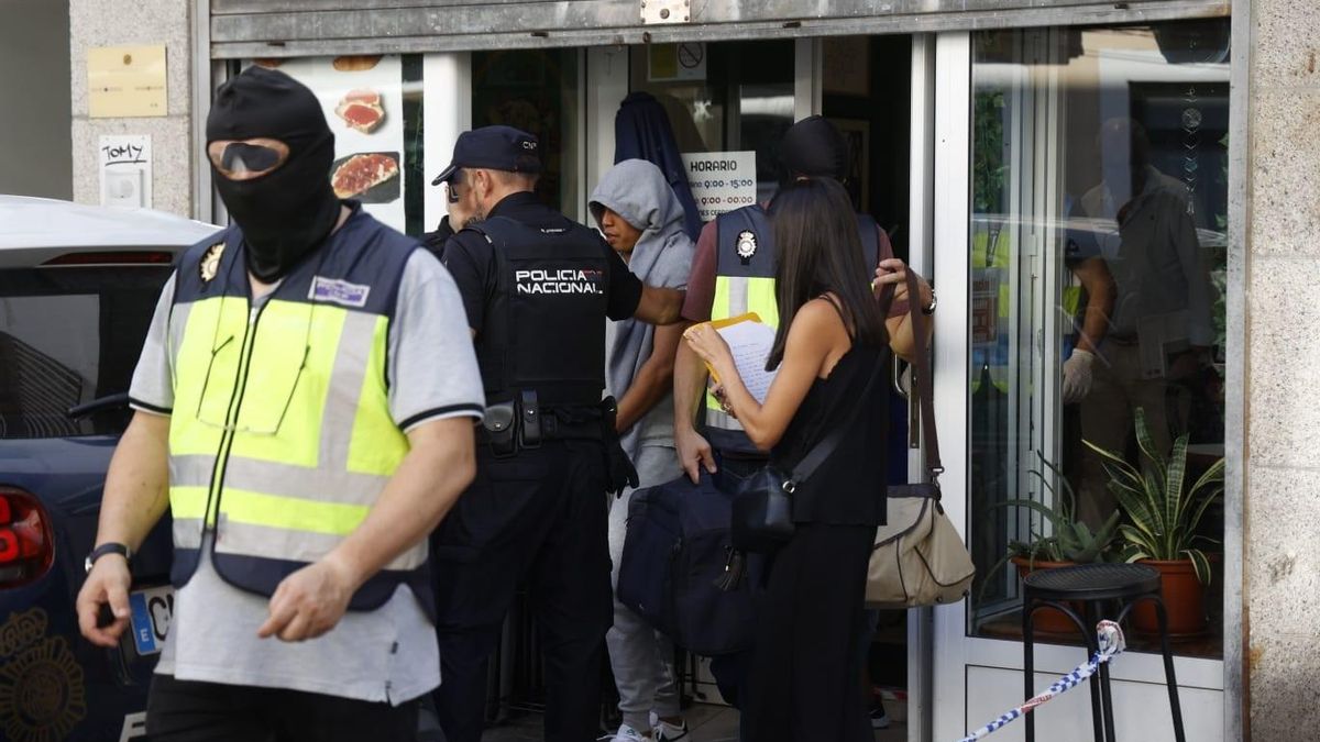 Uno de los detenidos, al fondo, con capucha
