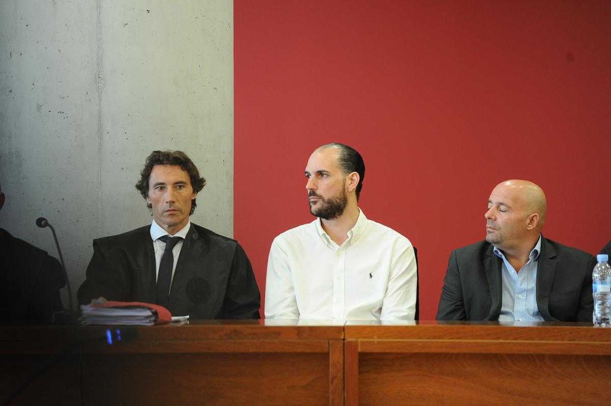 Juan Cuenca (c), su abogado, Pablo Ruiz Palacios (i) y Stan (d), en el banquillo en 2016.