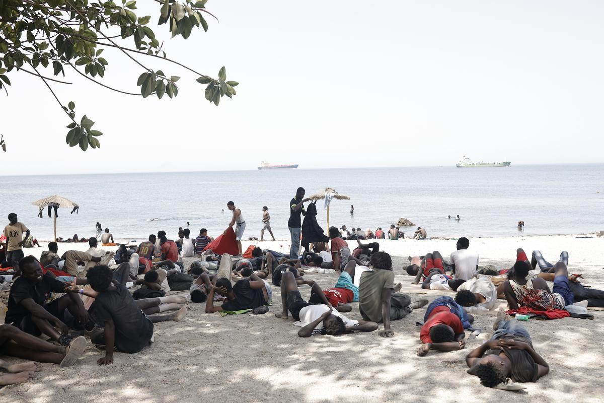 Varios migrantes en la playa de Ceuta.