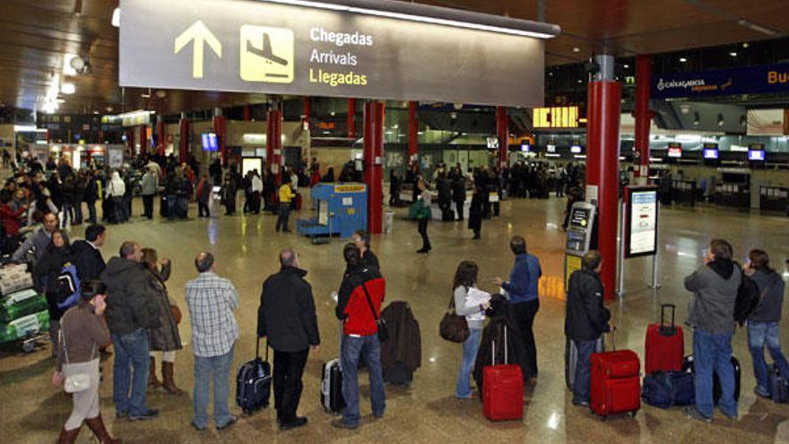 Cientos de afectados hacen cola ante el mostrador de Iberia en el aeropuerto de Vigo para informarse del paro de         los controladores y de la posible salida de vuelos, ayer por la tarde.  // Marta Brea