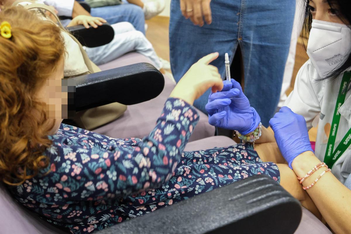 Vacunación a una niña en un colegio