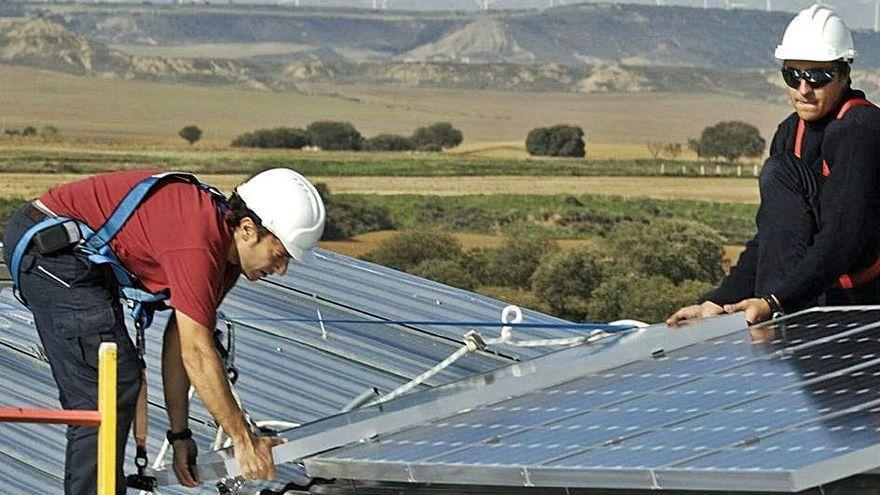 Operarios colocan placas fotovoltaicas.