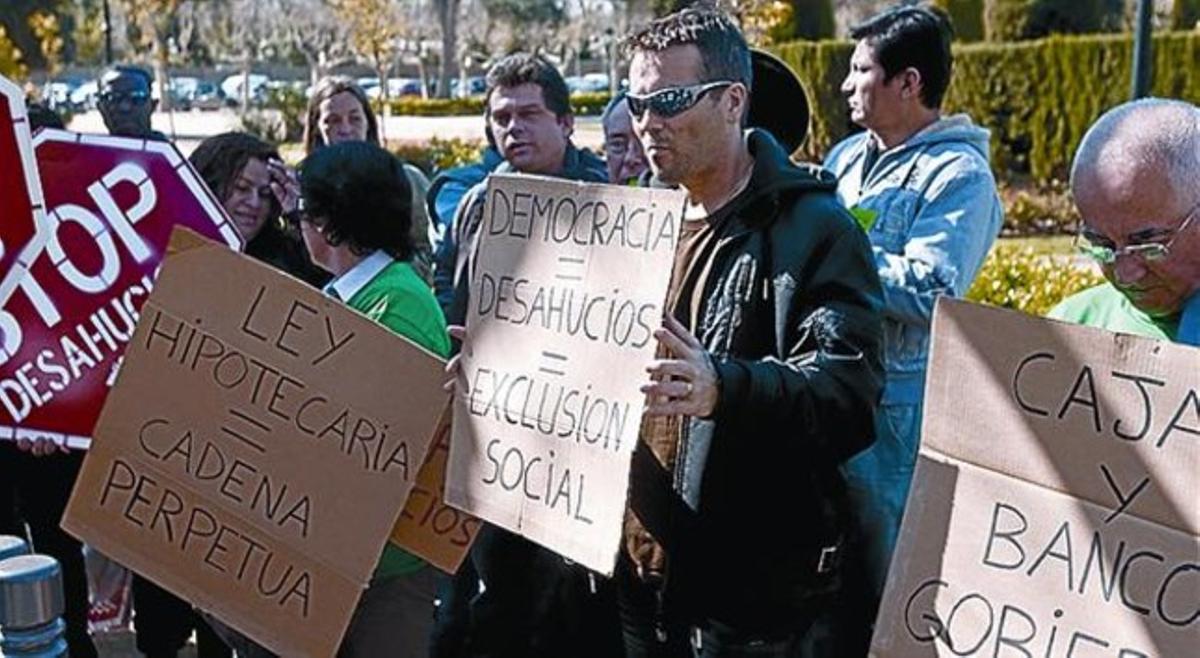 FRENTE AL PARLAMENT 3 Afectados por desahucios protestan ante el Parlament para pedir la modificación de la ley hipotecaria, el 23 de marzo.