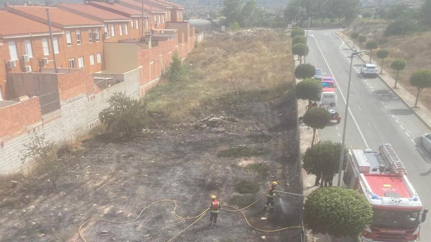 Los vecinos de La Romana intentan apagar con cubos y mangueras un incendio en una parcela urbana hasta la llegada de los bomberos
