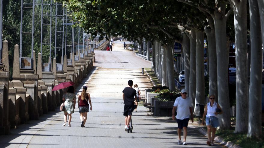 Vianants caminant per l'ombra a Lleida sota una intensa calor.