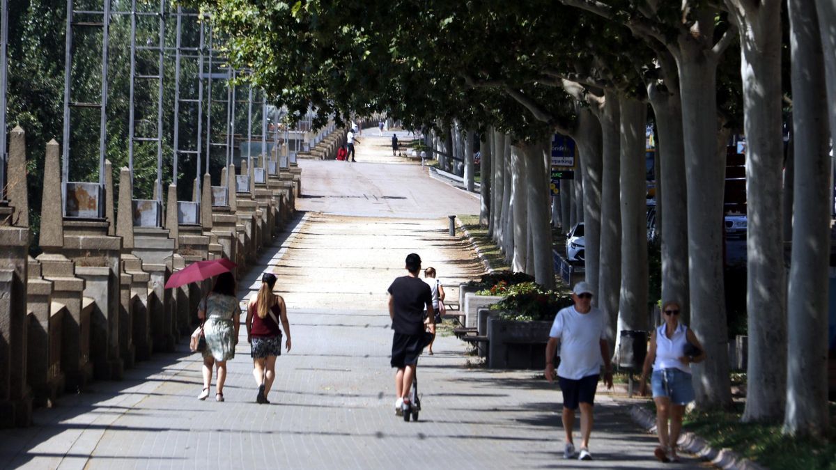 Vianants caminant per l'ombra a Lleida sota una intensa calor.