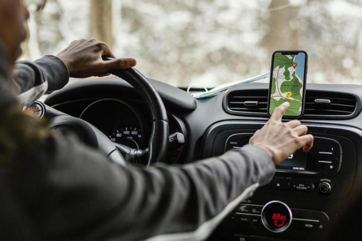 Un conductor consulta el GPS de su móvil.
