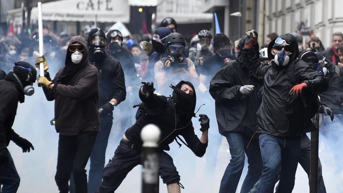 Un grupo de encapuchados lanza objetos contra la policía en París, el 14 de junio.