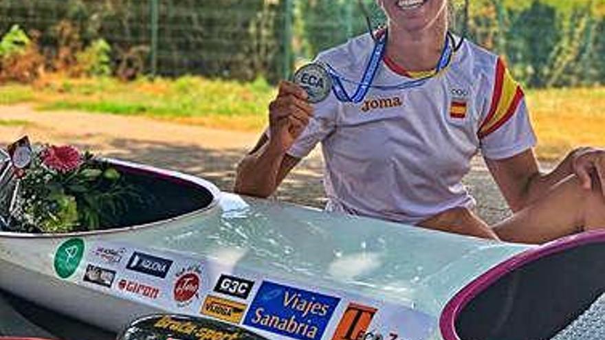 Eva Barrios posa con la medalla de plata junto a su kayak.