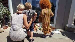 Uns nens ploren la mort de Cecil, davant la porta de la clínica del dentista que el va matar, a Bloomington Minneapolis.