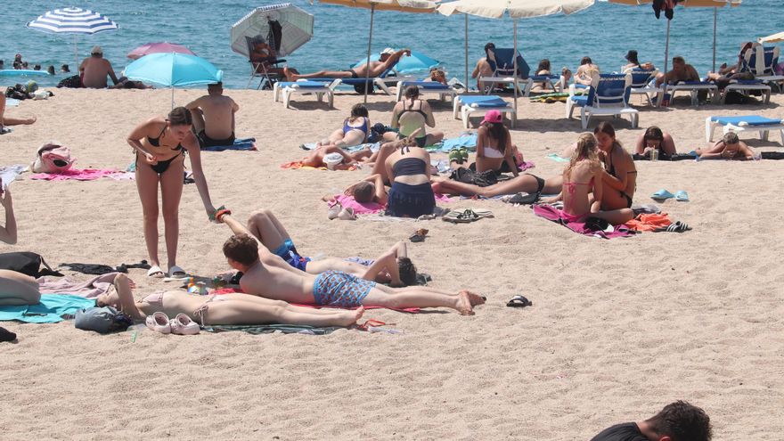 Alguns banyistes estirats a la sorra de la platja de Fenals de Lloret de Mar