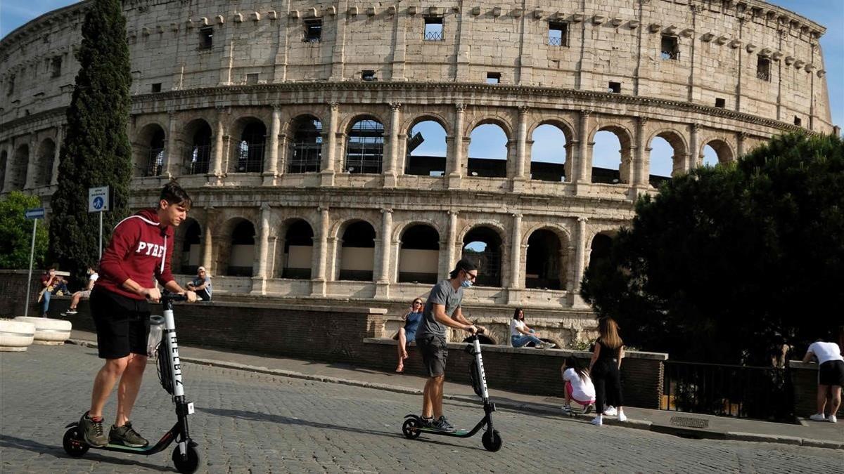 Vecinos de Roma pasean por el exterior del Coliseo.