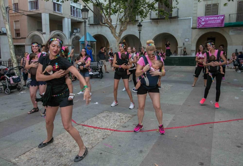 Un grupo de madres representa la canción central del musical «Mamma Mia» en la plaza de El Raval porteando a sus bebés