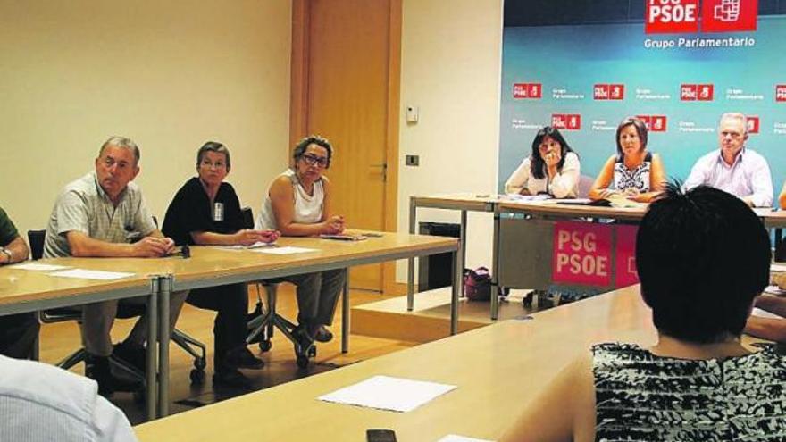 Afectados con los socialistas Laura Seara, Carmen Gallego y Antolín Sánchez, al fondo, ayer.  // FdV