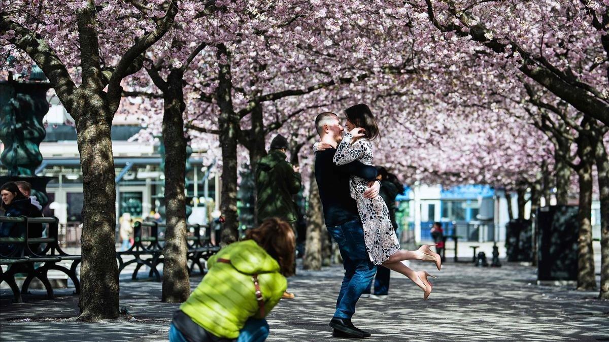 Una pareja se toma una foto en actitud cariñosa en un parque de Estocolmo.