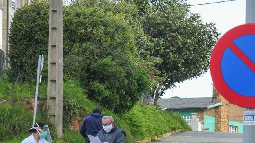 Una sanitaria acompaña a un paciente, el martes en Vilagarcía. /I.Abella