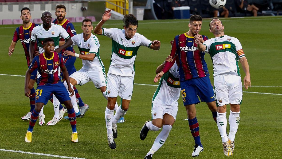 Jugadores del FC Barcelona y del Eleche CF pelean un balón durante el partido correspondiente al trofeo Joan Gamper disputado esta tarde en el estadio Camp Nou, en Barcelona.