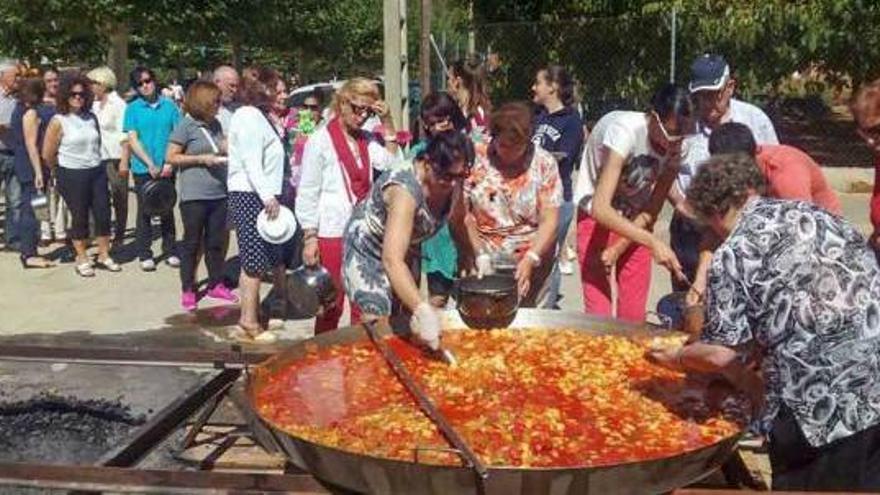 La alcaldesa de Morales del Rey, Elsa Fernández (centro), sirviendo patatas con carne a los vecinos .