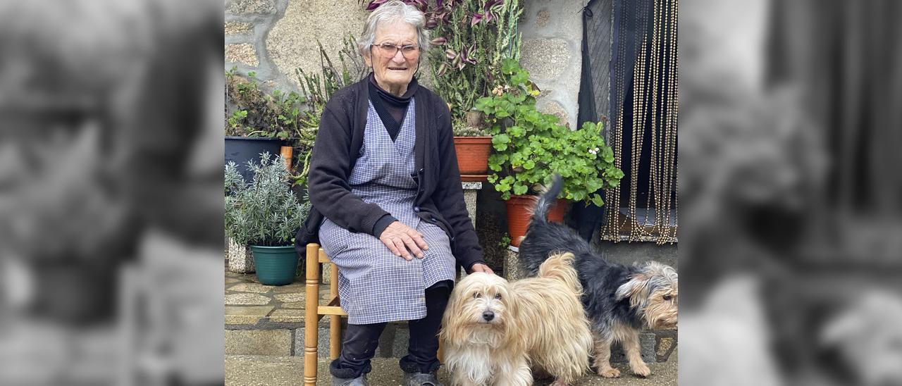 Saladina Fernández, junto a dos de sus perros, en la puerta de su casa en Salvatrerra.