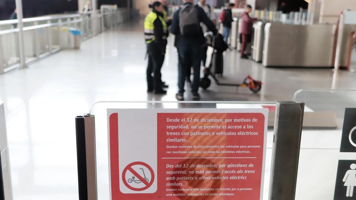 Personal de Renfe y Adif informan a un usuario de la prohibición de subir al tren en patinete, ayer en Castelló