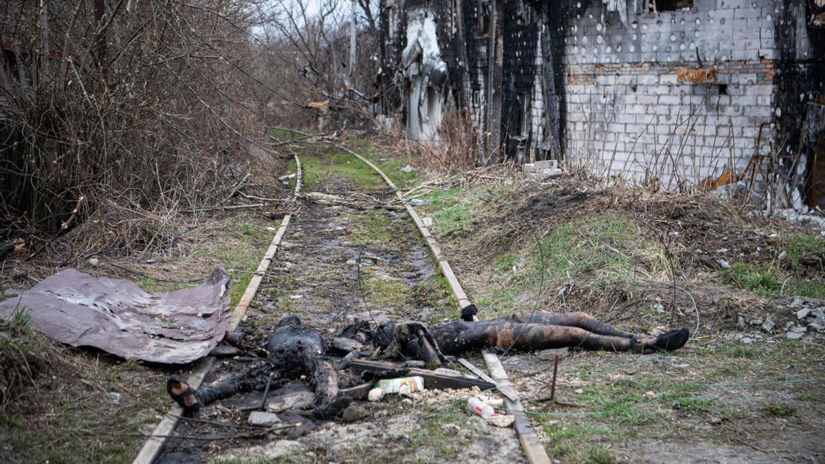 Dos cadàvers cremats al costat d’una casa destrossada a la localitat d’Irpin. | EUROPA PRESS