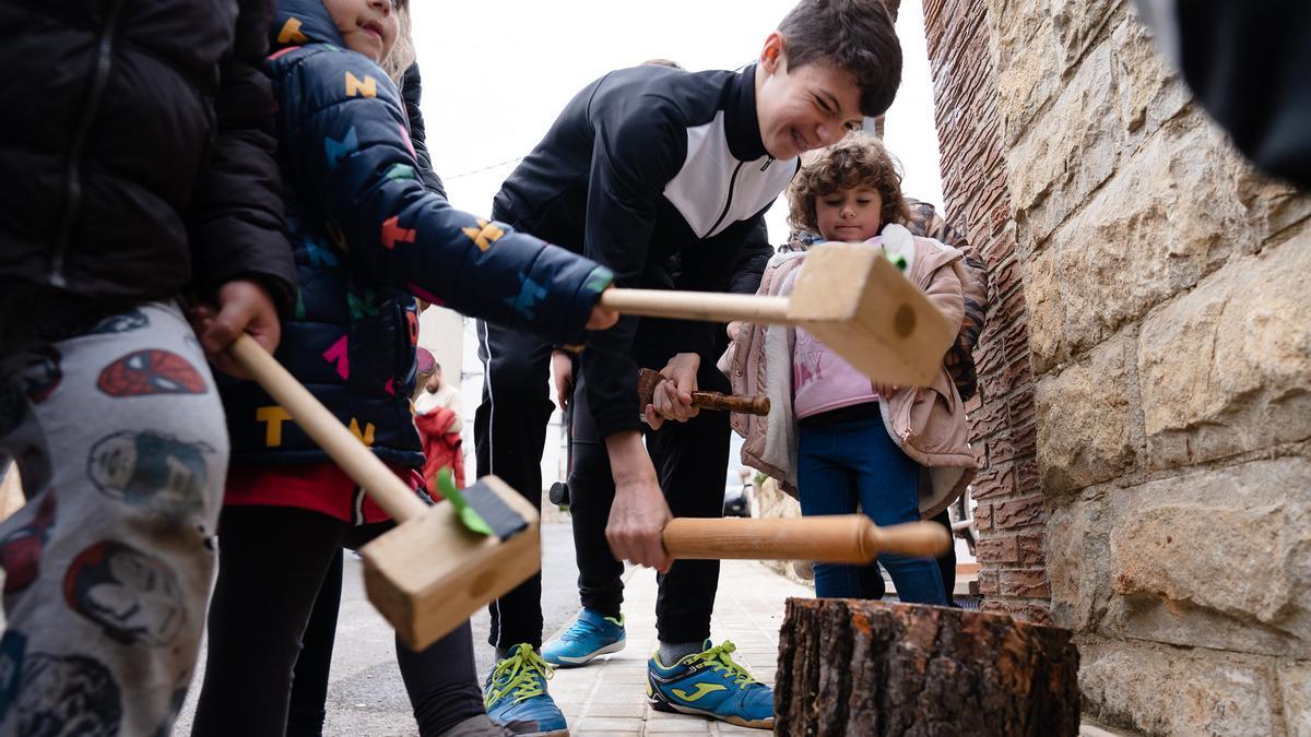 Niños golpeando un tronco en la celebración de la Salpassa de Otos en 2022.