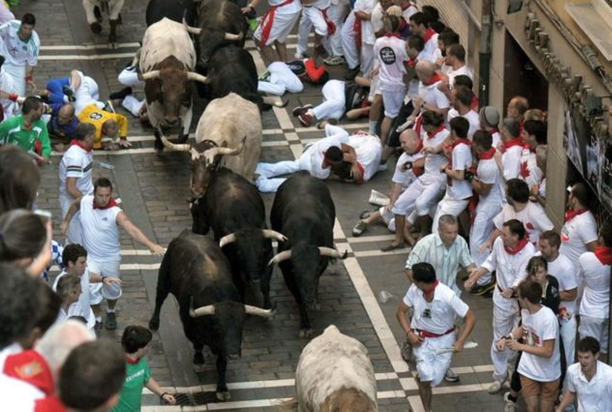 La manada al seu pas pel carrer Estafeta, on diversos mossos han caigut davant els toros durant la carrera.