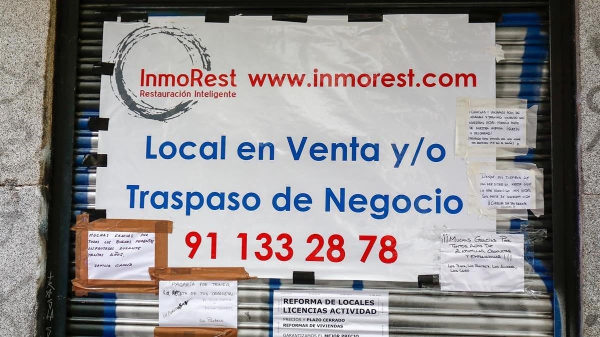 Cartel que anuncia la venta o traspaso en la persiana una cafetería de Madrid.