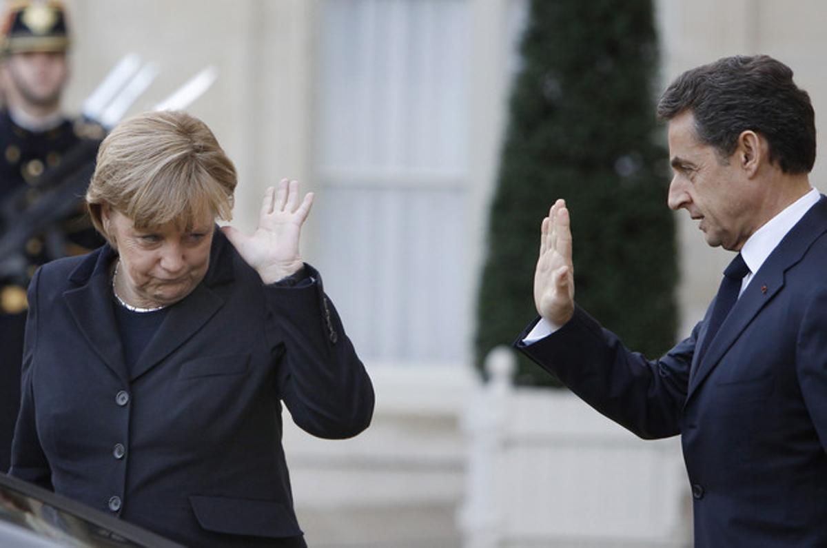 Angela Merkel i Nicolas Sarkozy s’acomiaden després de la seva reunió dilluns a París.