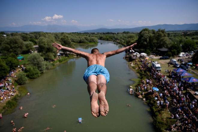 Un participante salta desde el puente Ura e Shenjte durante el tradicional concurso anual de salto de gran altura en Gjakova.