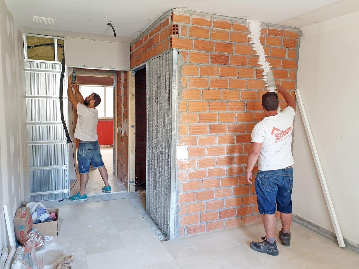 ALBAÑILES TRABAJANDO EN UNA OBRA DE REFORMA DE UNA VIVIENDA.