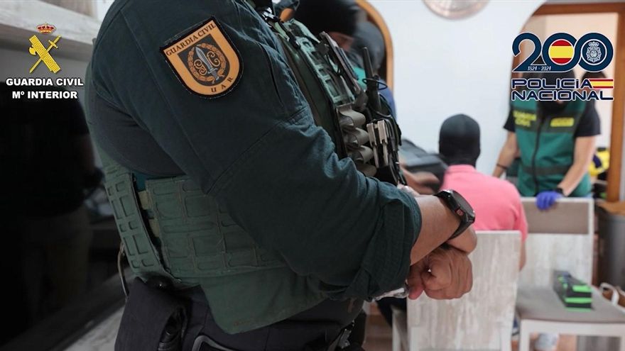 Agente de la Guardia Civil en el registro de un domicilio por el robo en 13 sucursales bancarias.