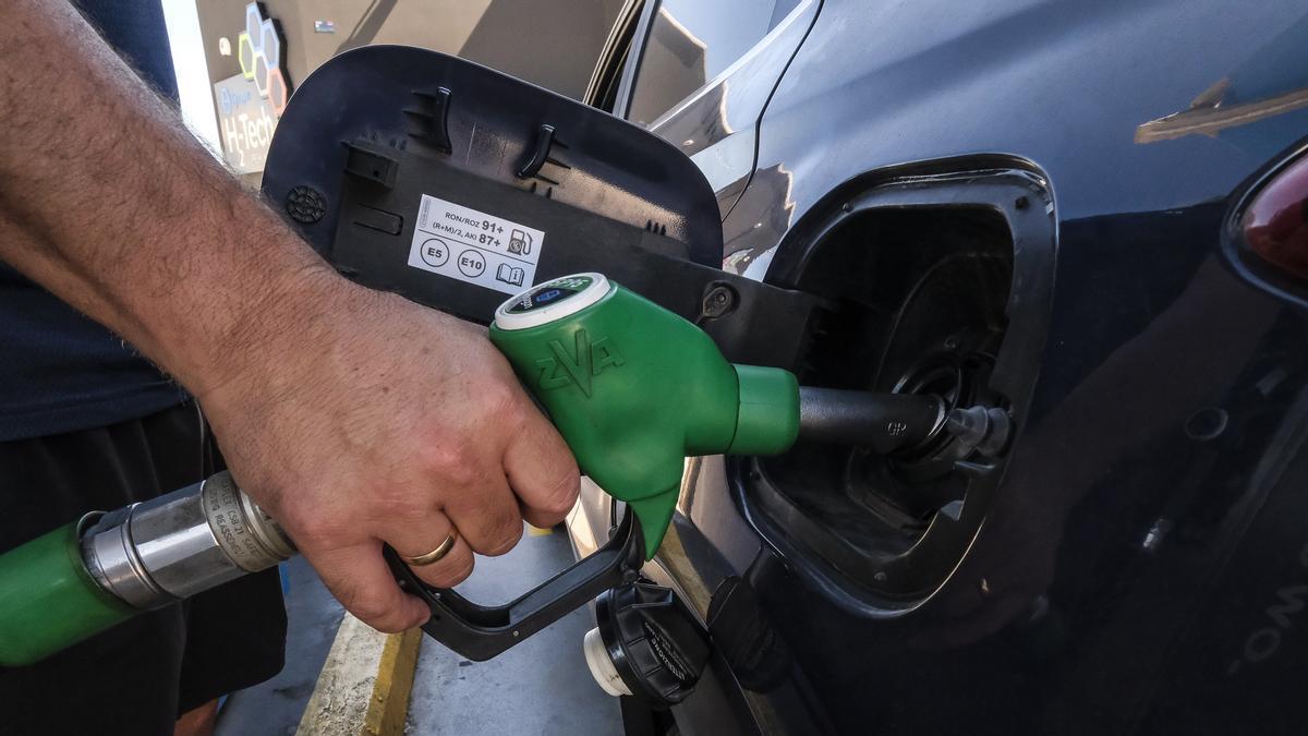 Un señor reposta su coche en una gasolinera.