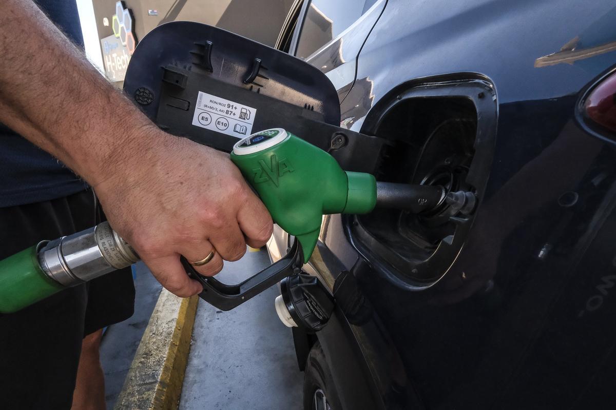 Un señor reposta su coche en una gasolinera.