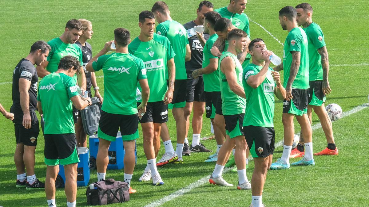 Los futbolistas del Elche beben agua, durante el descanso de un entrenamiento