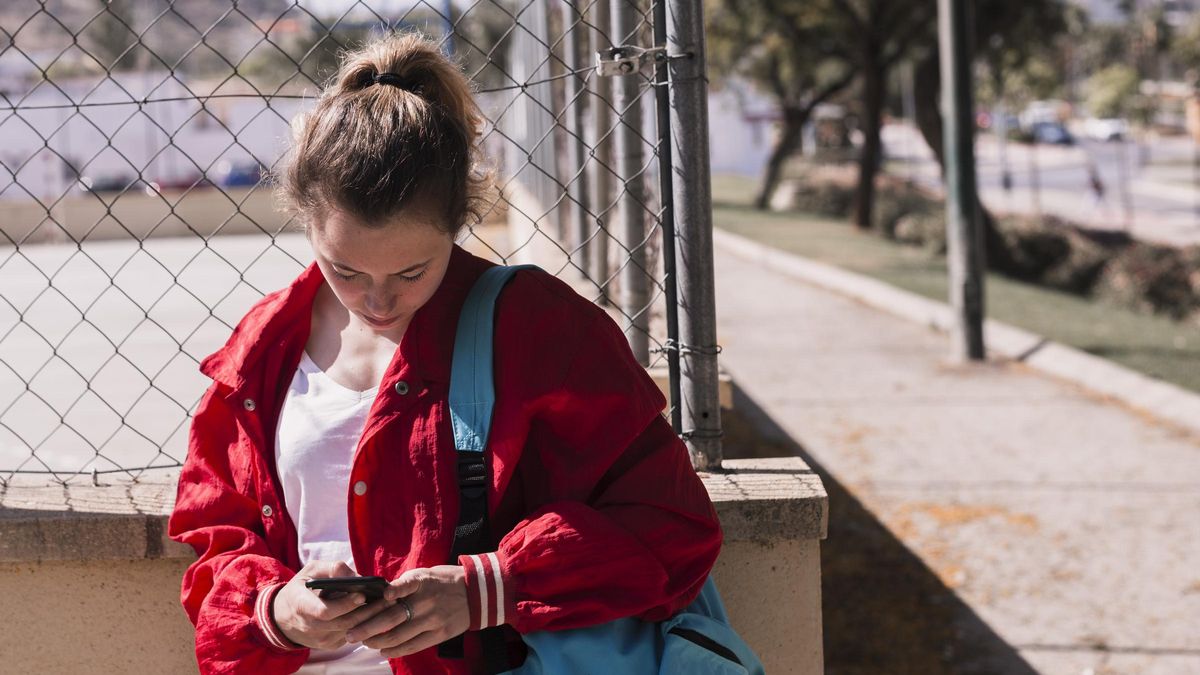 Una jove consulta el seu telèfon mòbil