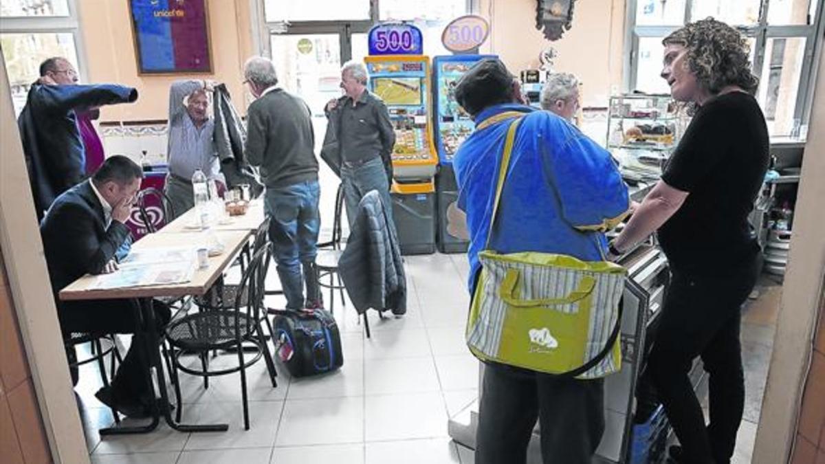 Laura Albéniz, a la derecha, charla con un cliente en el bar Gelida del Eixample, donde una parte de la clientela son personas mayores del barrio que hace años que acuden.