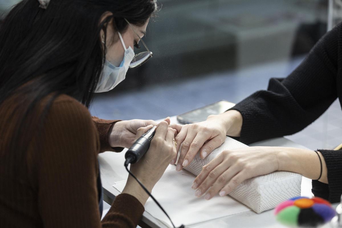 Una manicurista hace las uñas a una clienta en un establecimiento de Alicante.