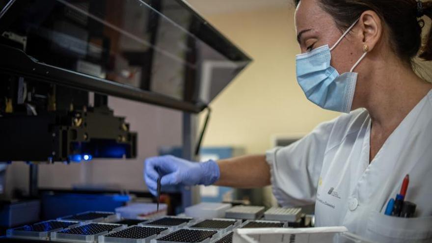 Una investigadora del Hospital Universitario de Canarias (HUC) deposita muestras sospechosas de coronavirus en una máquina para hacer PCR.